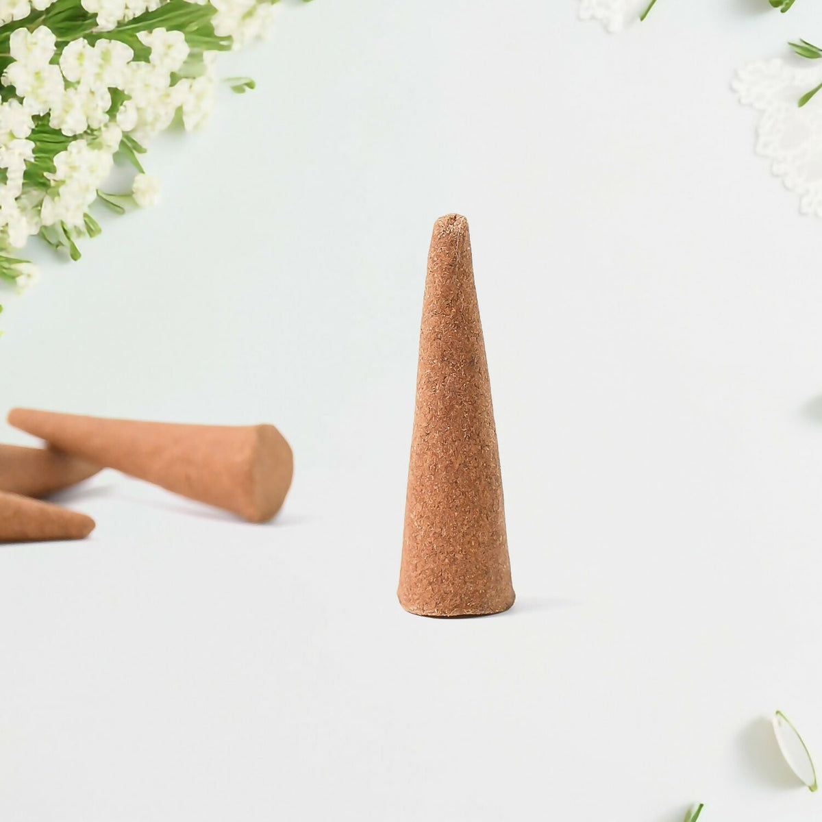 Resin dhoop cone held in hand for scale