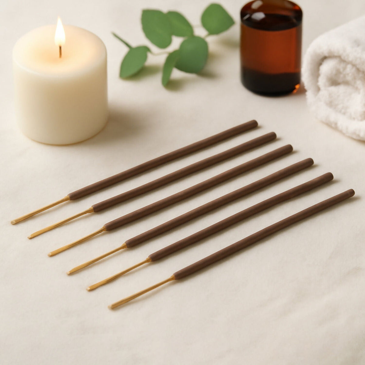 Agarbatti sticks laid out beside a candle