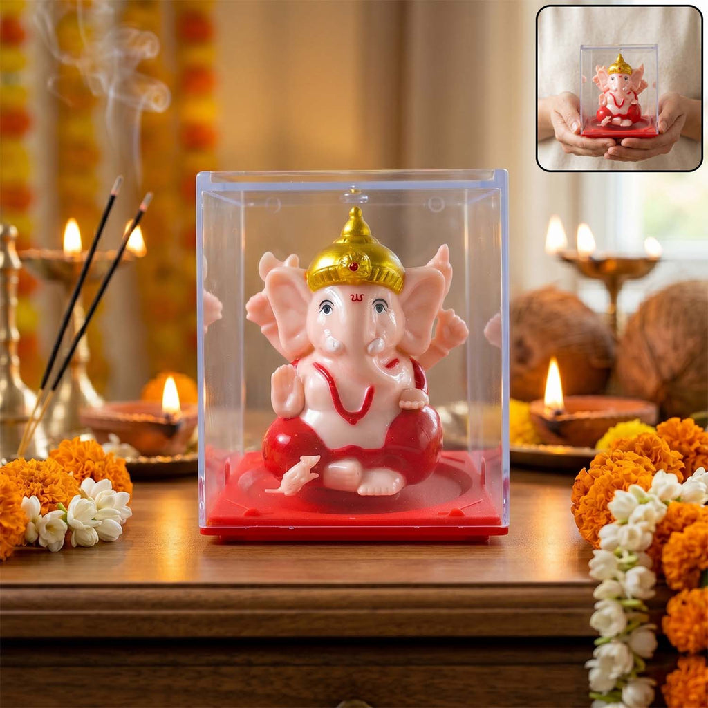 Small red and gold Ganesha idol in a clear case
