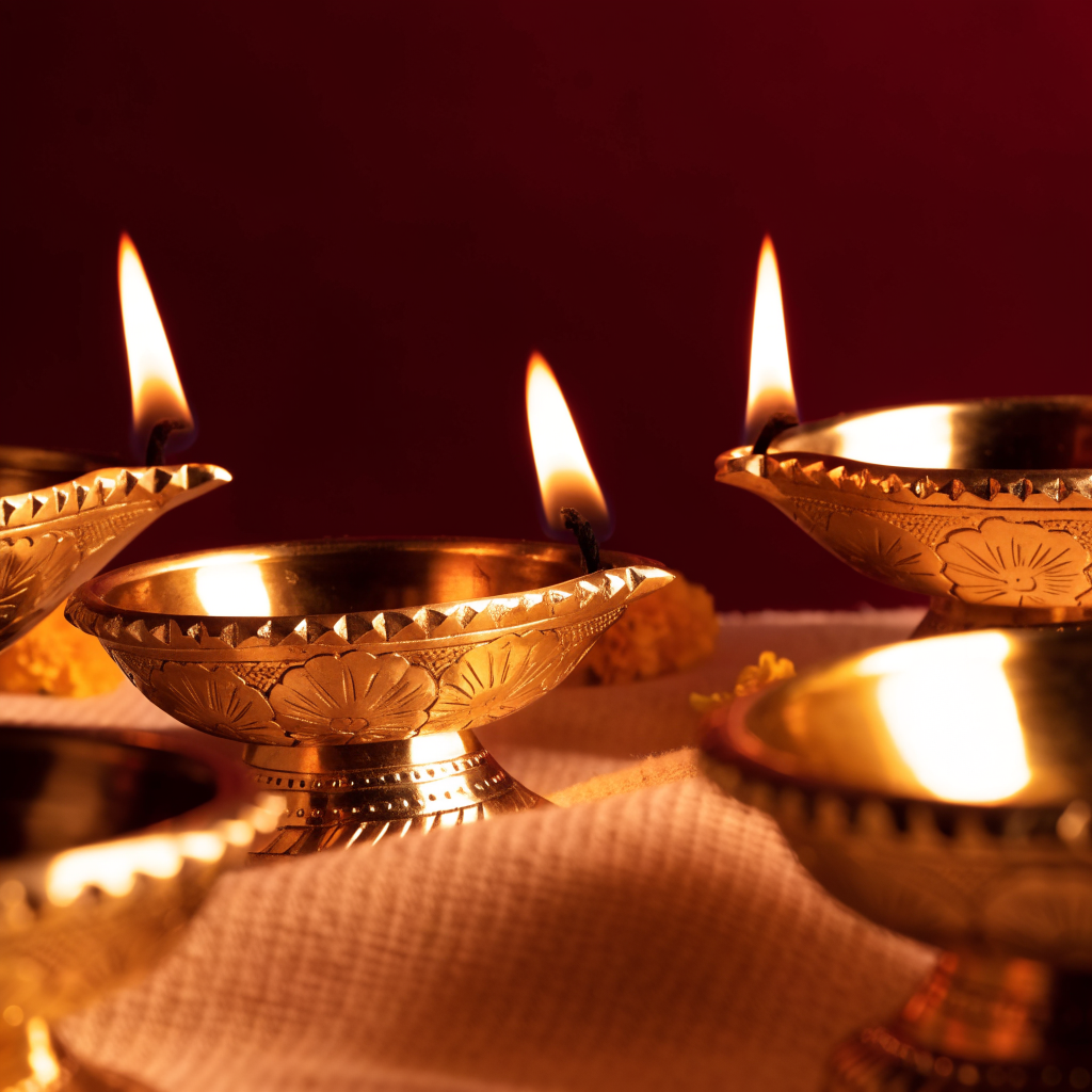 Handcrafted brass diya oil lamps with warm flames
